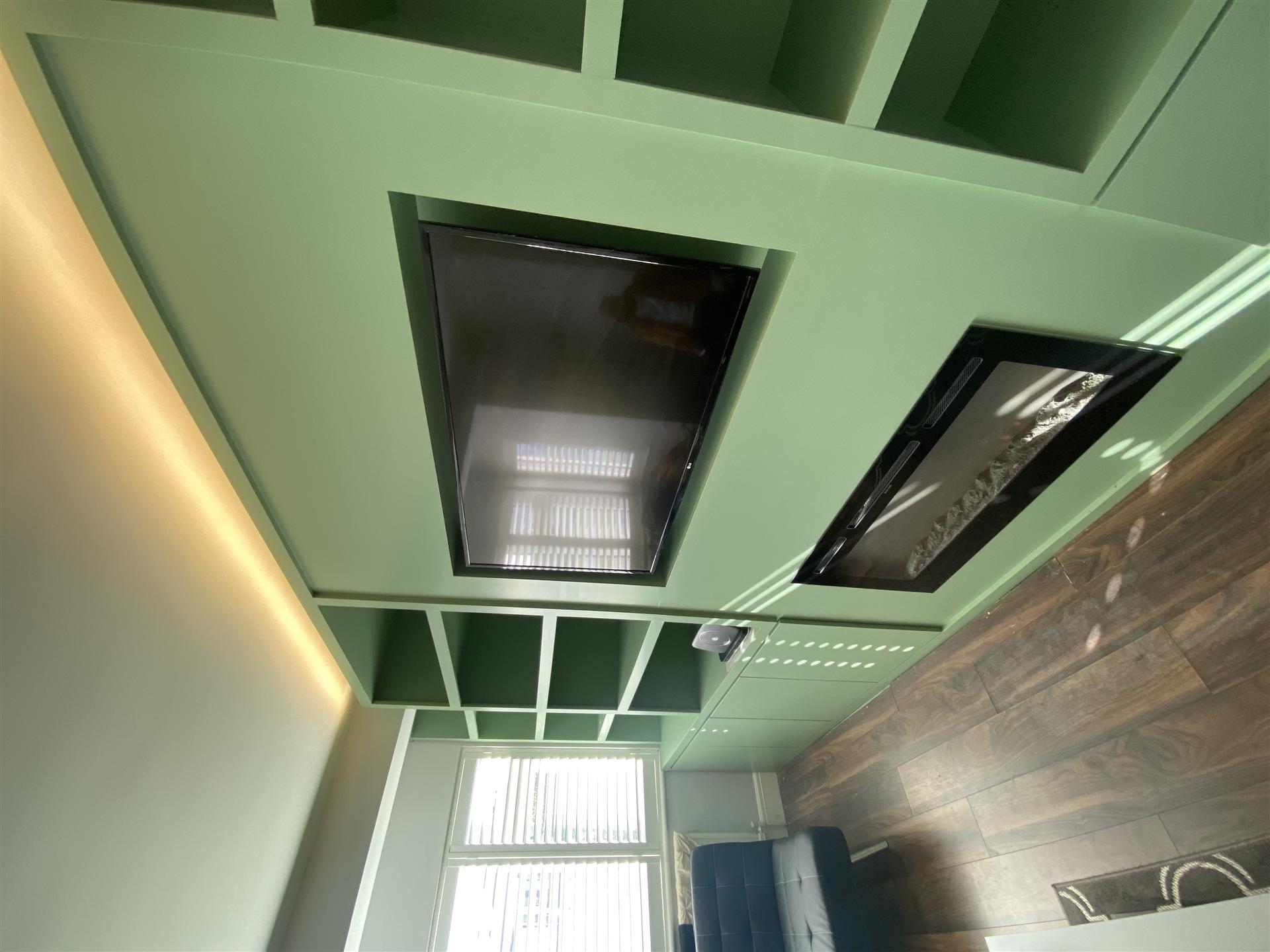 Spray-painted green built-in shelving with fireplace, Essex